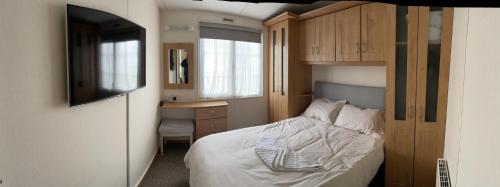 a bedroom with a bed and a desk and a television at Luxurious Beach Resort & Golf Club in Hunstanton