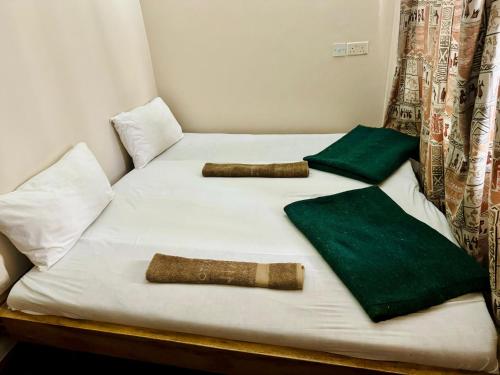 a bed with two pillows and a bat on it at Arusha Backpackers Hotel in Arusha