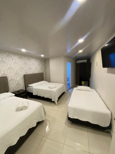 a room with two beds and a flat screen tv at Borabora hotel in San Andrés