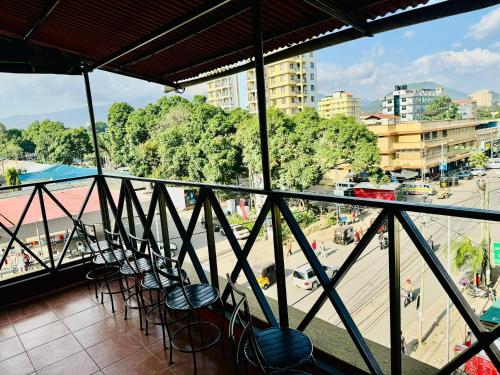 a balcony with chairs and a view of a city at Arusha Backpackers Hotel in Arusha