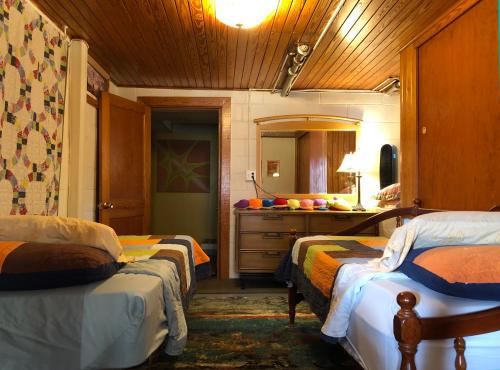 a bedroom with two beds and a sink and a mirror at Hummingbird Suite at Lake J in Lake Junaluska