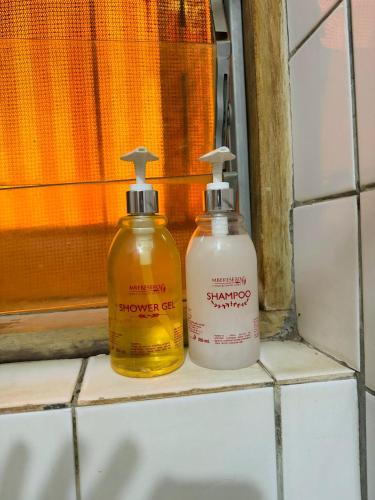 two bottles of cleaning products sitting on a window sill at Arusha Backpackers Hotel in Arusha