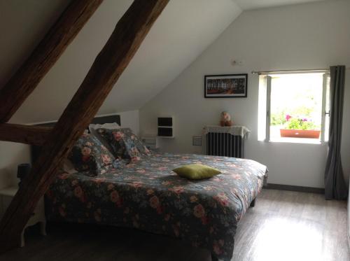 Schlafzimmer mit einem Bett und einem Fenster in der Unterkunft La bicoque en Puisaye in Saint-Amand-en-Puisaye