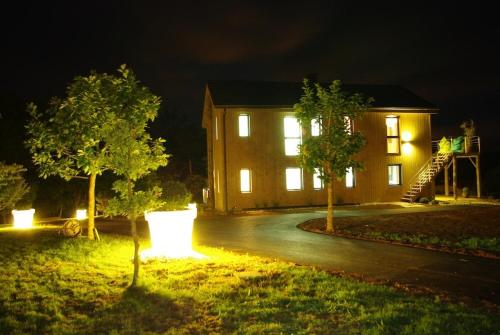 una casa con luces en el patio por la noche en Le Domaine de l'Ô - Lofts Contemporain au Coeur du Perigord, en Saint-Jean-dʼEyraud