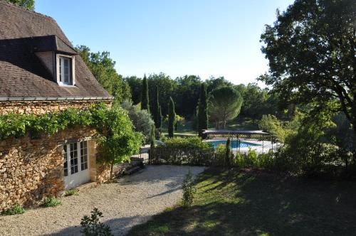 une maison en pierre avec une clôture et une piscine dans l'établissement Périgord Sarlat Lascaux piscine privée chauffée Delsud, à Coly