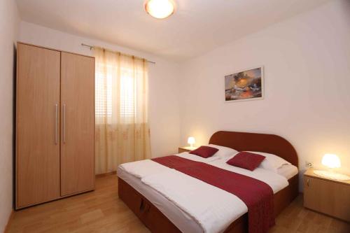 a bedroom with a large bed with two red pillows at Apartment in Silo/Insel Krk 13564 in Šilo