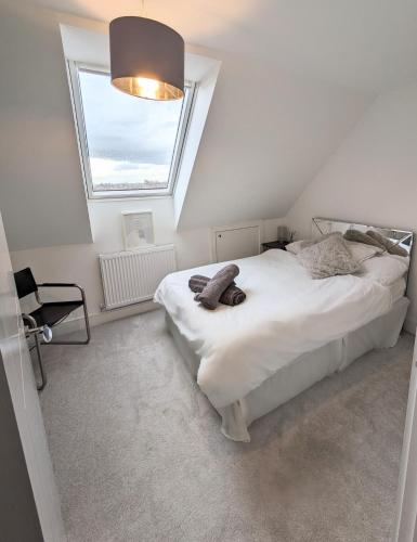 a bedroom with a white bed with a window at The Penthouse Double Bedroom for Rent Use of kitchen in Epsom