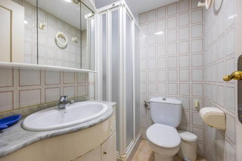 Baño blanco con aseo y lavamanos en Fuentes de Nerja B2G Apartamento Vacacional, en Nerja