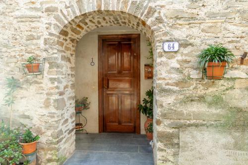 - une entrée pour un bâtiment en pierre avec une porte en bois dans l'établissement Casa Gigina, à Stazzema