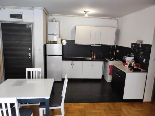a kitchen with white cabinets and a white table and a table and a tablektop at Fildor in Zagreb
