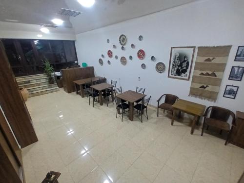 a restaurant with tables and chairs in a room at Uzbegim Family Guest House in Bukhara