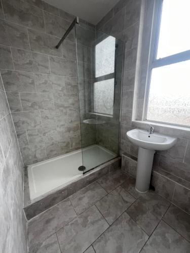a bathroom with a shower and a sink at Greatstone Lodge in Manchester