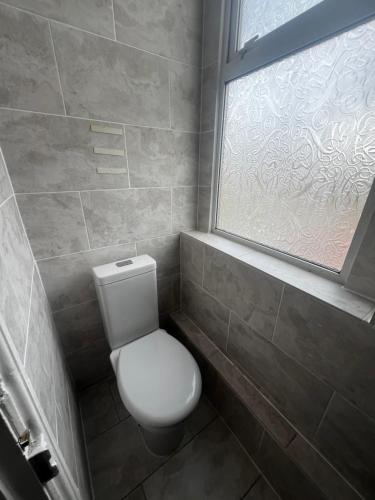 a bathroom with a white toilet and a window at Greatstone Lodge in Manchester