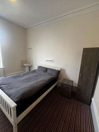 a bedroom with a bed and a sink at Greatstone Lodge in Manchester