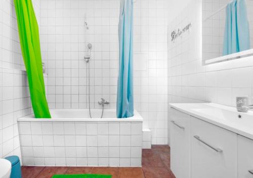 baño con bañera y ducha con cortinas verdes en Modern 2 Bedroom Apartment in Midtown West, en Nueva York