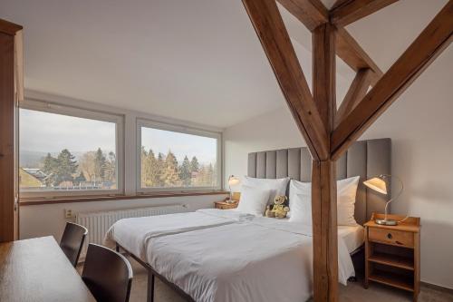 a bedroom with a bed with a teddy bear sitting on it at Pytloun Wellness Travel Hotel in Liberec