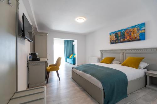 1 dormitorio con 1 cama y 1 silla amarilla en Sky Rooms by Volo Guest House en Sub Coastă