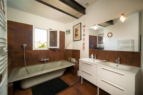 La salle de bains est pourvue d'une grande baignoire et d'un lavabo. dans l'établissement Maison air conditionné, piscine, quartier calme proche des plages, à Marseille