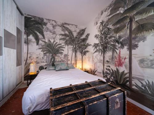 - une chambre avec un lit orné d'une fresque murale de palmiers dans l'établissement Maison air conditionné, piscine, quartier calme proche des plages, à Marseille
