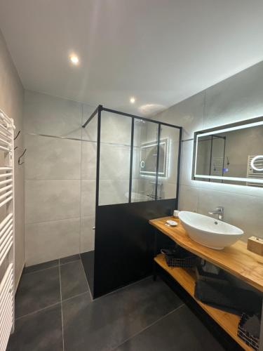 a bathroom with a sink and a shower at la ruche Bel appartement avec terrasse, magnifique vue , 2 spa in Gérardmer