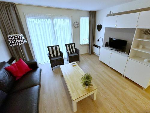 ein Wohnzimmer mit einem Sofa und einem Tisch in der Unterkunft Appartement Kompas in Hollum