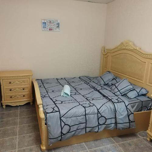 a bed with a blue comforter and pillows on it at العين الهيلي مصباح ب1 in Al Ain