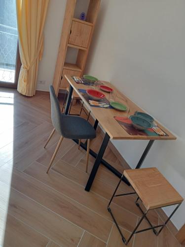 a wooden table with a chair and a table and stool at IL NIDO DEL FALCO in Pitigliano