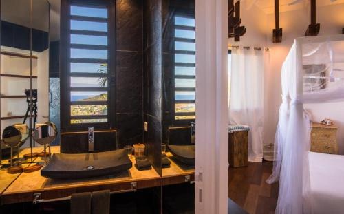 uma casa de banho com um lavatório num balcão ao lado de uma cama em Luxury Vacation Villa 19 em Marigot