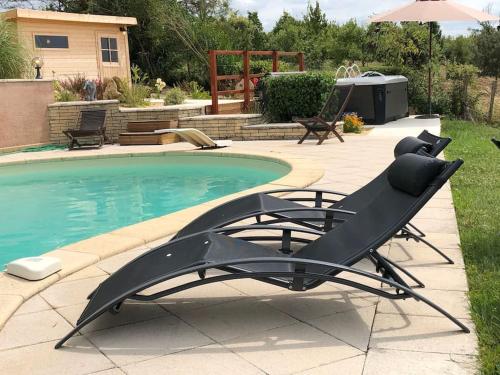 een zwembad met een ligstoel naast een zwembad bij Grande maison en pierre avec piscine, sauna et jacuzzi in Madaillan