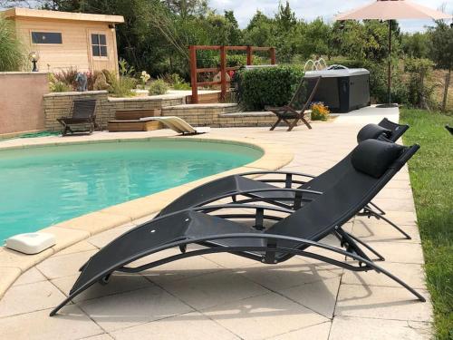 - une piscine avec un fauteuil inclinable à côté de la piscine dans l'établissement Grande maison en pierre de taille avec piscine, sauna et jacuzzi, à Madaillan