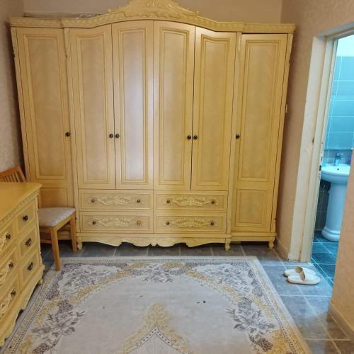 a large wooden cabinet in a room with a rug at العين الهيلي مصباح ب1 in Al Ain
