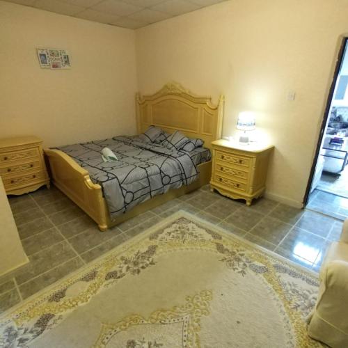 um quarto com uma cama e duas mesas de cabeceira e uma cama sidx sidx sidx em العين الهيلي مصباح ب1 em Al Ain