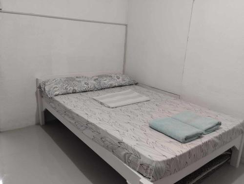 a small bed in a white room with a mattress at Vin's Place Rentals - Studio Unit in Tagum
