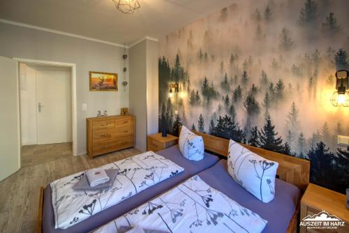 um quarto com duas camas e um quadro na parede em Auszeit im Harz Haus 1 Wohnung Feuerstein em Schierke