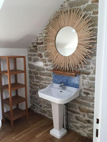 une salle de bain avec un lavabo et un miroir sur un mur dans l'établissement Le Récif, maison indépendante Corniche de la mer, à Concarneau