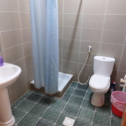 uma casa de banho com um WC, um lavatório e um chuveiro em العين الهيلي مصباح ب1 em Al Ain