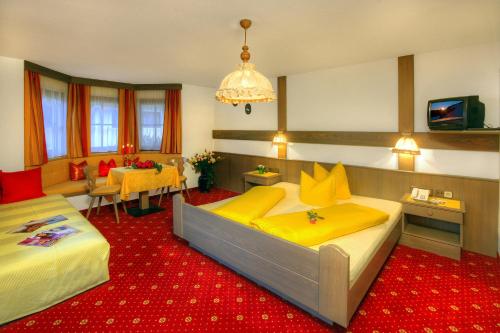 two beds in a room with a red carpet at Pension Zur alten Mühle in Sölden