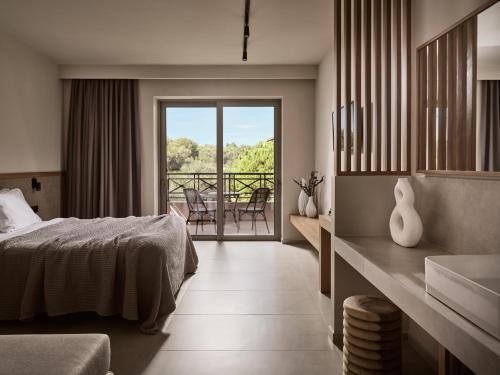 a bedroom with a bed and a balcony at Alamis Hotel & Apartments in Tsilivi