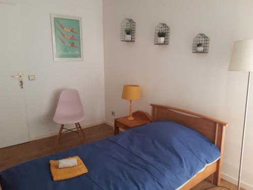 - une chambre avec un lit bleu et une chaise dans l'établissement Appartement 3 chambres 5 couchages, à Versailles