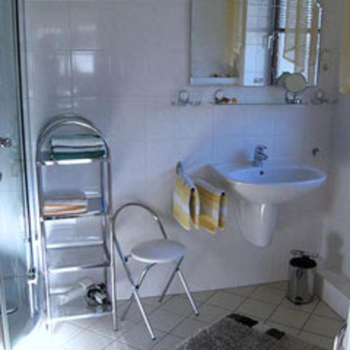 a white bathroom with a sink and a shower at Fewo Leopold - Ferienwohnung 1 in Cuxhaven