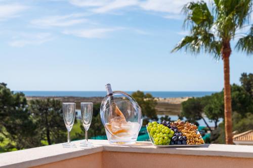 a plate of fruit and wine glasses on a ledge at Extraordinary Villa on an elevated position in Quinta do Lago in Quinta do Lago