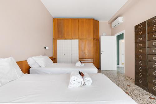 - 2 lits dans une chambre d'hôtel avec des serviettes dans l'établissement Brera Apartments in Porta Ticinese, à Milan