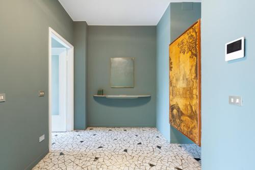 ミラノにあるBrera Apartments in Porta Ticineseの青い壁のバスルーム(壁に絵画付)