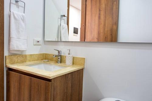 uma casa de banho com um lavatório e um espelho em H602 - Cozy Garden View, Fast WiFi & Rooftop Pool em Cali