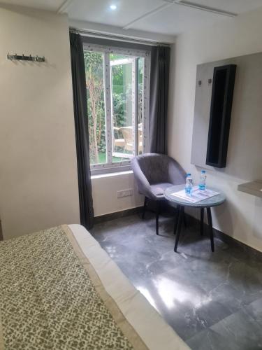 a room with a bed and a table and a window at City View With Garden -5 Mins Walk From GOLDEN TEMPLE in Amritsar