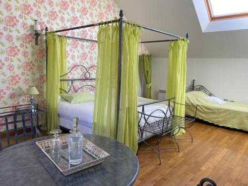 a room with a bed and a table with a table sidx sidx at La Closerie des Sacres in Lavannes
