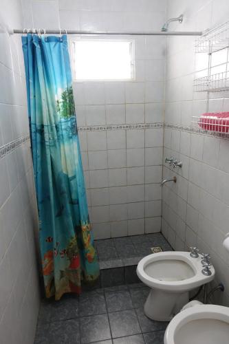 een badkamer met een toilet en een douchegordijn bij Departamentos VILLAHERMOSA de Un Dormitorio - Dos Dormitorios y Monoambientes in San Clemente del Tuyú