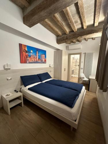 a bedroom with a large bed with blue sheets at Residenza Pezzani in Parma