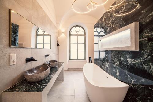 ein Badezimmer mit zwei Waschbecken und einer großen Badewanne in der Unterkunft NEW LUXUS Suite I TWO Kingbeds I Center I Netflix in Augsburg