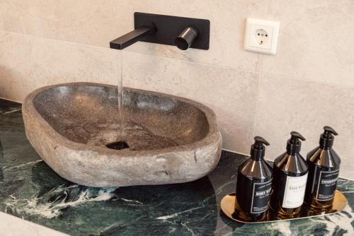 a bathroom with a sink with three bottles at NEW LUXUS Suite I TWO Kingbeds I Center in Augsburg